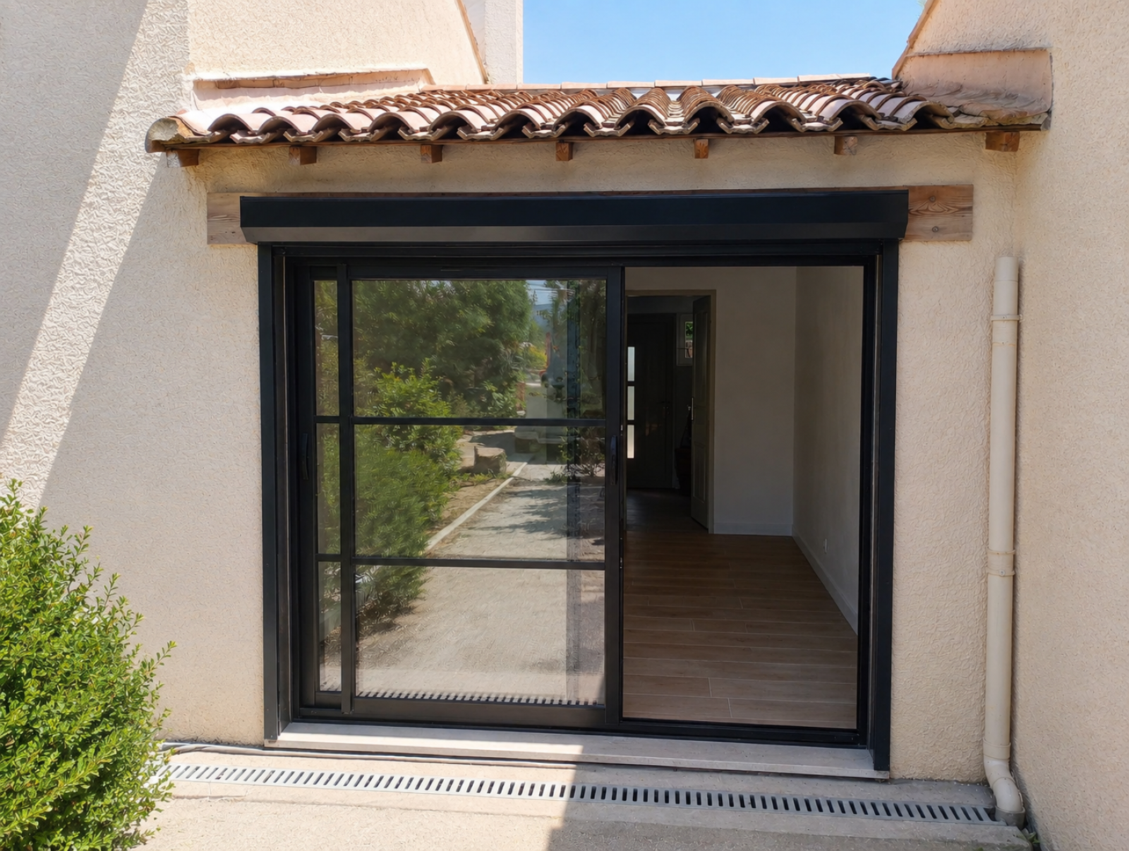 Installation d’une baie vitrée coulissante en aluminium 2 vantaux 2 rails sur mesure à Villeneuve les Avignon avec petits bois et volet roulant coffre extérieur