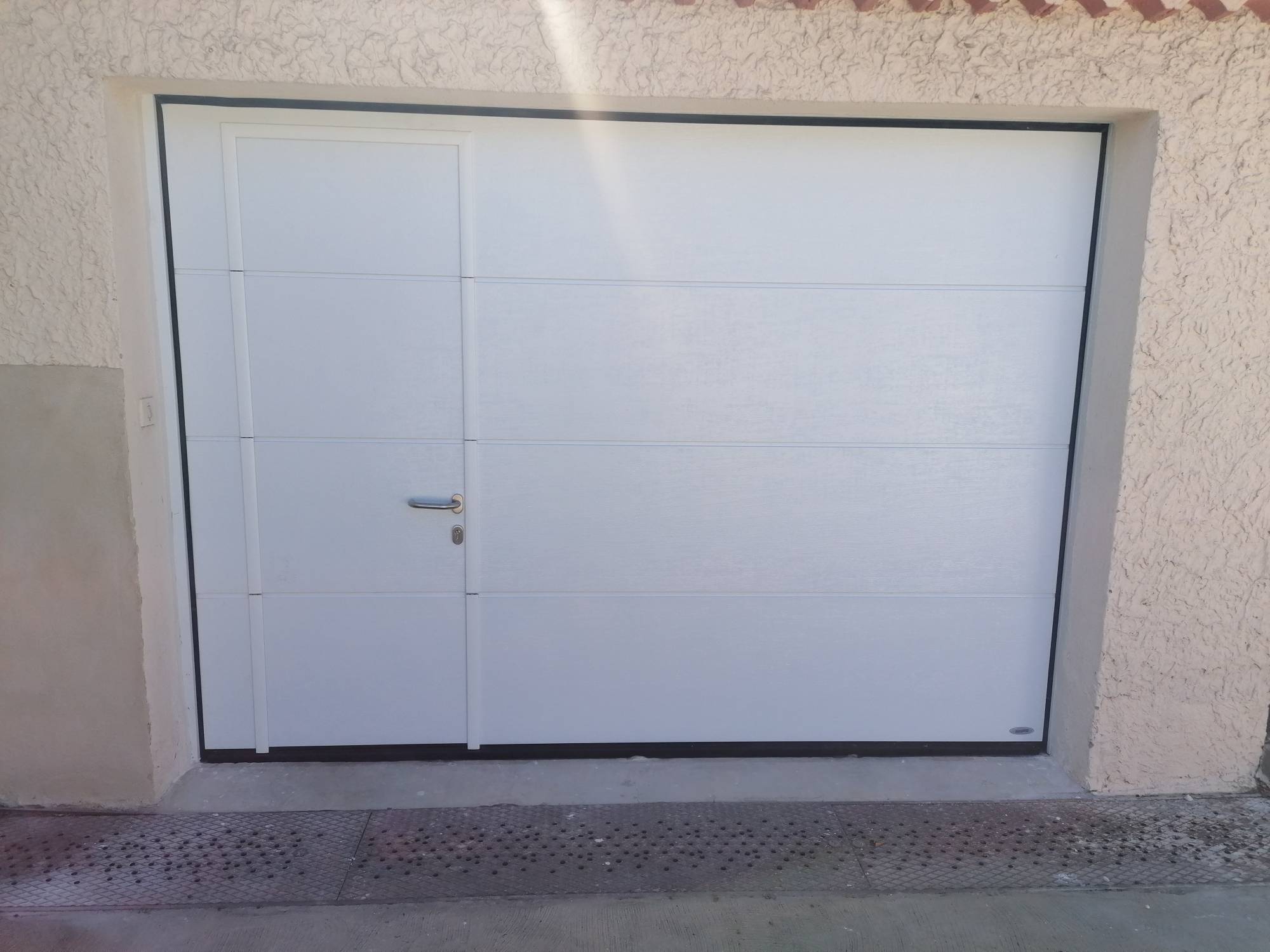 Installation d'une porte de garage sectionnelle avec portillon ouverture intérieure sur mesure motorisée dans le Vaucluse près d'Avignon( Le Pontet) 84