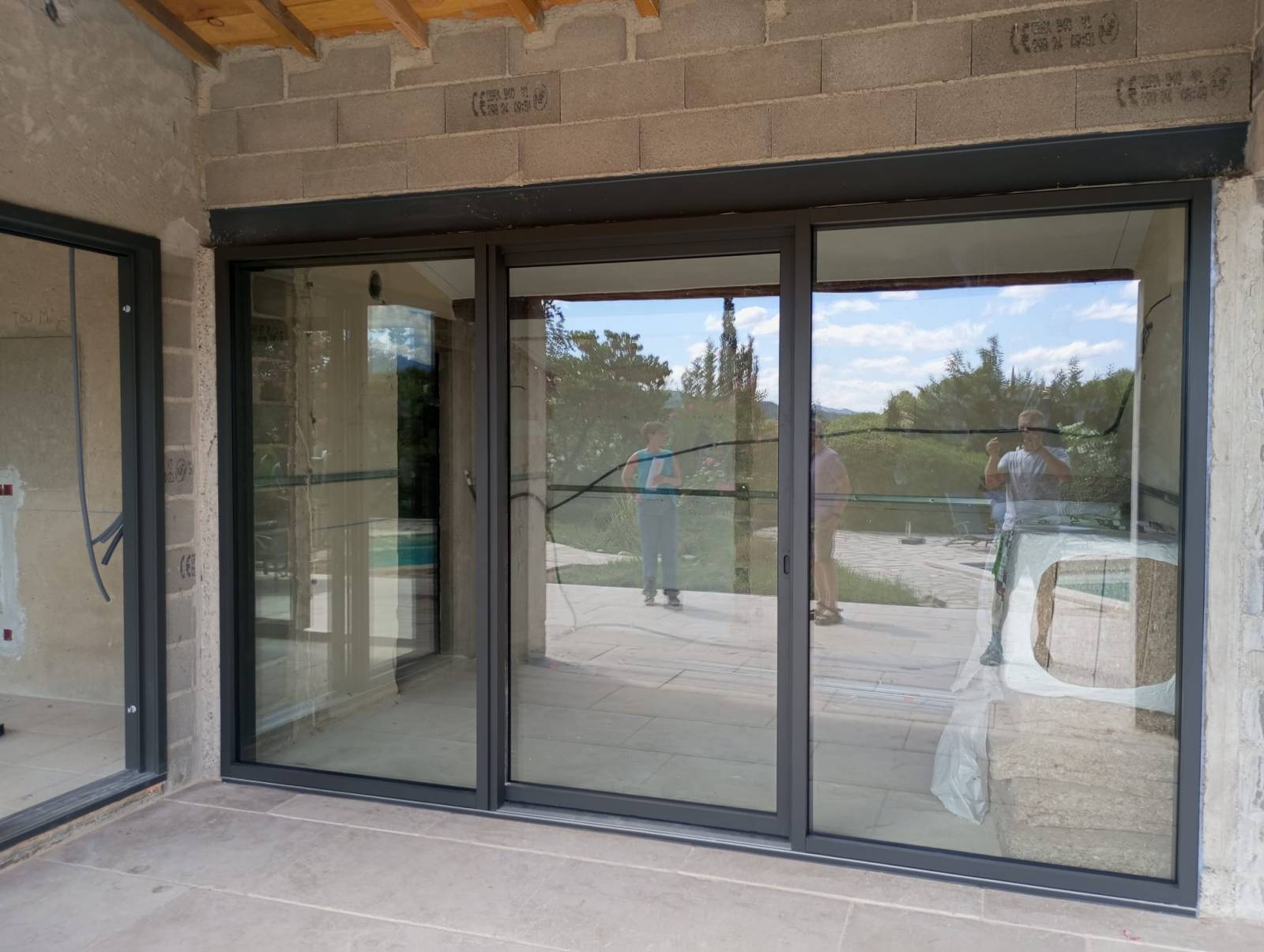 Mise en place d’une baie coulissante à levage en aluminium sur Mirabel aux Baronnies, avec châssis fixes latéraux et double vitrage feuilleté