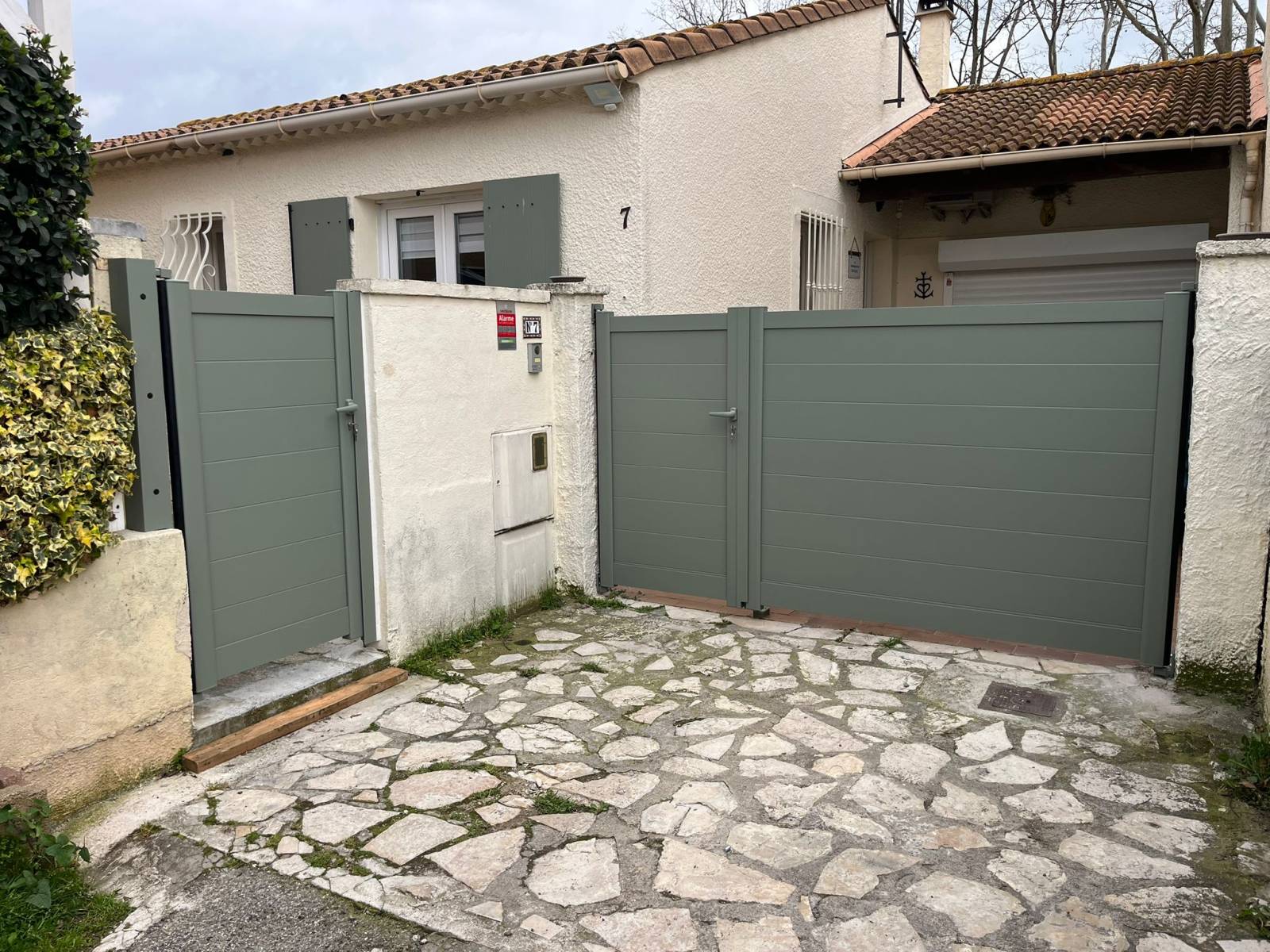 Pose d’un portail battant asymétrique manuel en aluminium sur mesure à Arles avec pose de portillon
