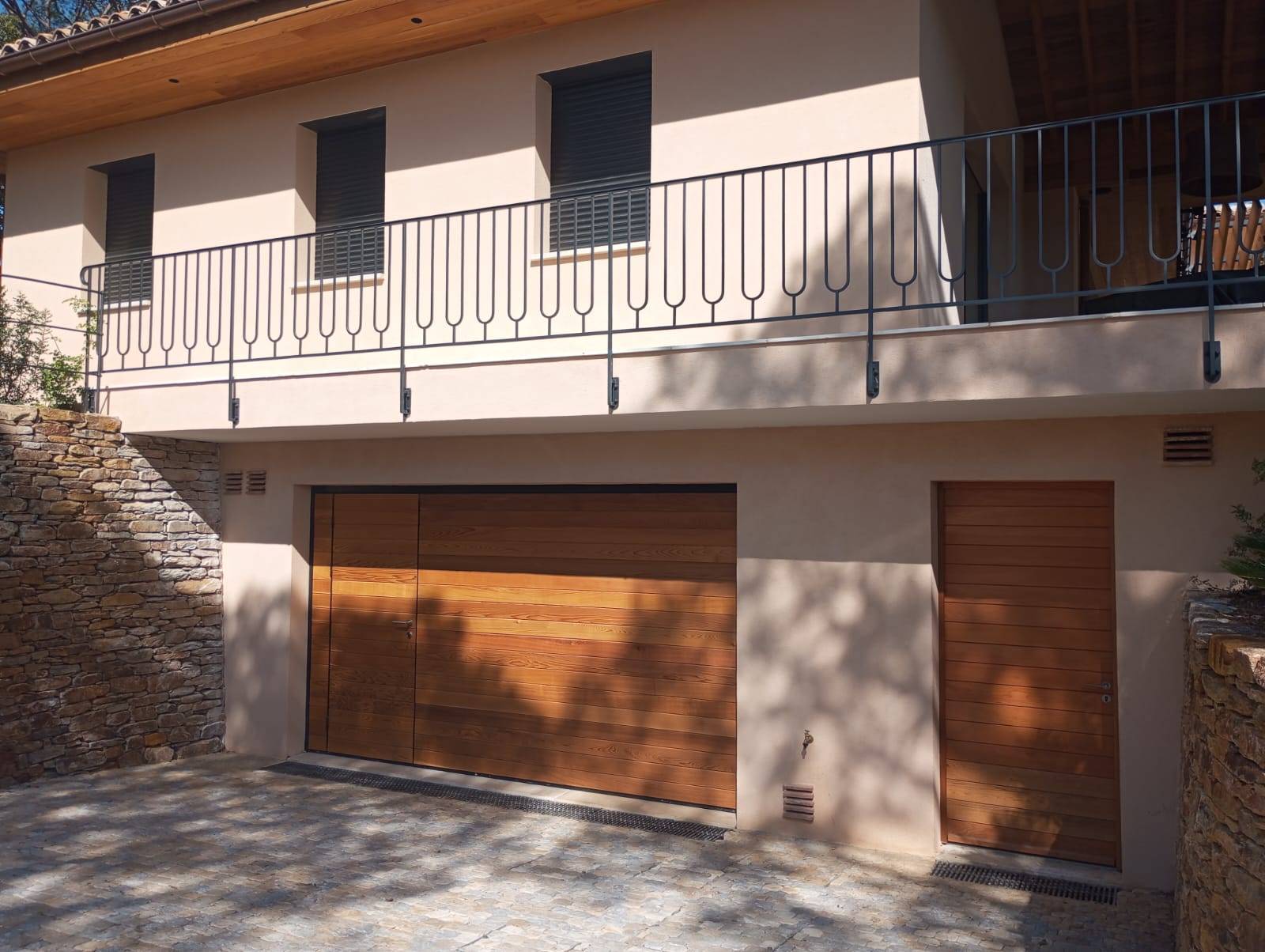 Pose d’une porte de garage basculante motorisée sur mesure en bois à Ramatuelle avec portillon intégré 