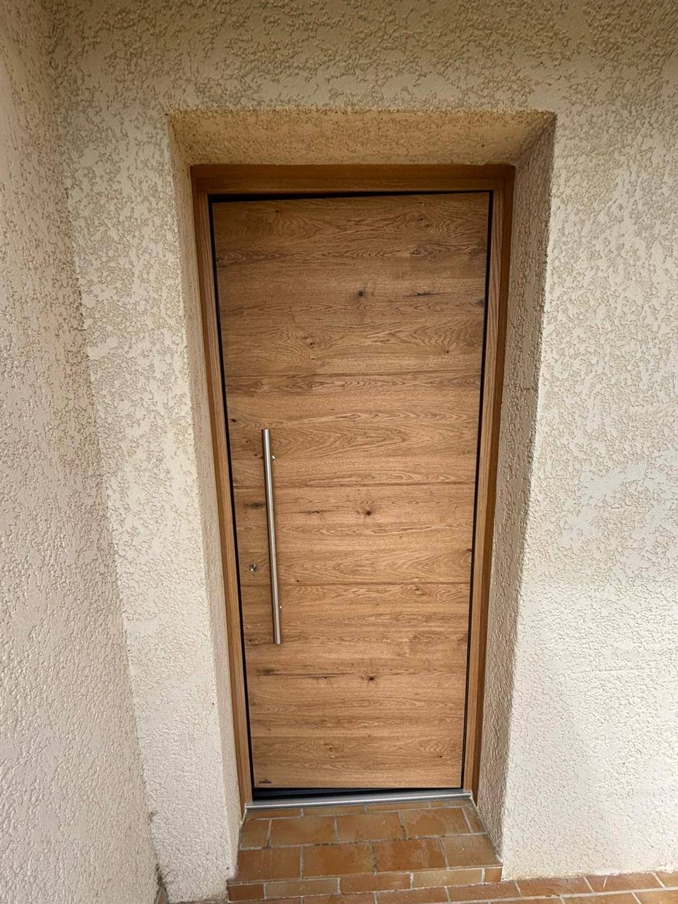 Pose d’une porte d’entrée en bois premium sur mesure à Villeneuve les Avignon avec barre de tirage et cylindre de sécurité