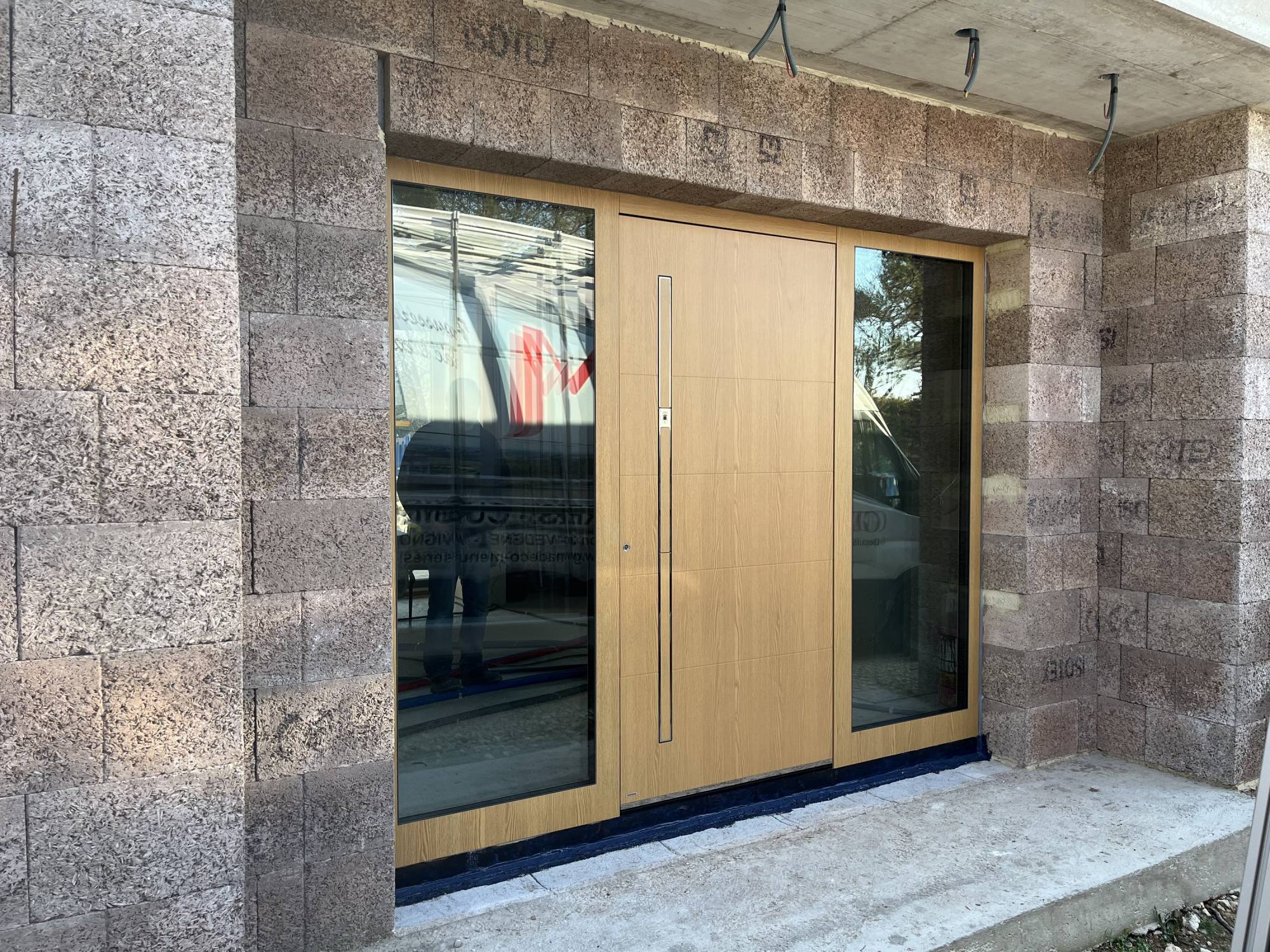 Pose en tunnel d'une porte d'entrée en aluminium grande largeur haut de gamme avec châssis latéraux fixes vitrés à Gordes dans le Lubéron (84)