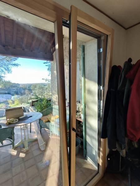 Installation en rénovation d'une porte-fenêtre avec oscillo-battant en bois alu à côté de Montfavet (Caumont sur Durance)